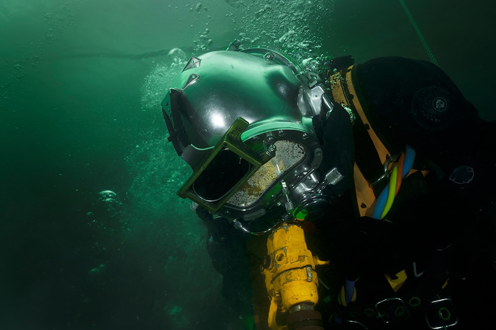 professional diver working underwater with pneumatic tools